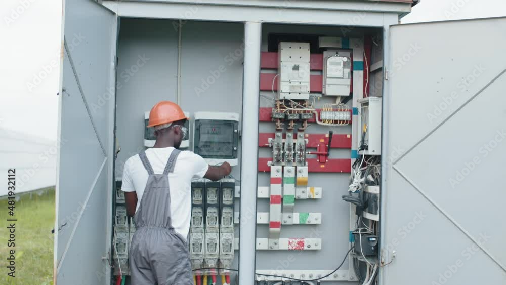 Concept of people, maintenance and alternative energy. Electrical Systems Equipment Power Distribution Cabinet. Multiracial people examining process of green energy production. Power transformer. Concept of people, maintenance and alternative energy. Electrical Systems Equipment Power Distribution Cabinet. Multiracial people examining process of green energy production. Power transformer.