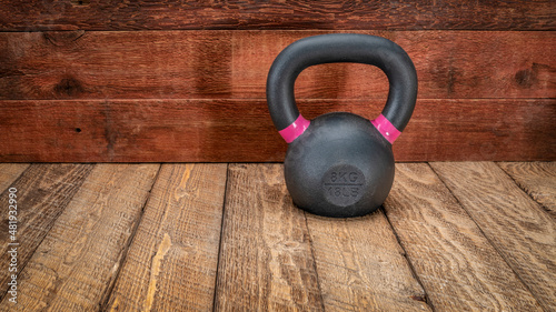 Fototapeta Naklejka Na Ścianę i Meble -  small iron kettlebell on a rustic wood background with a copy space, home fitness concept