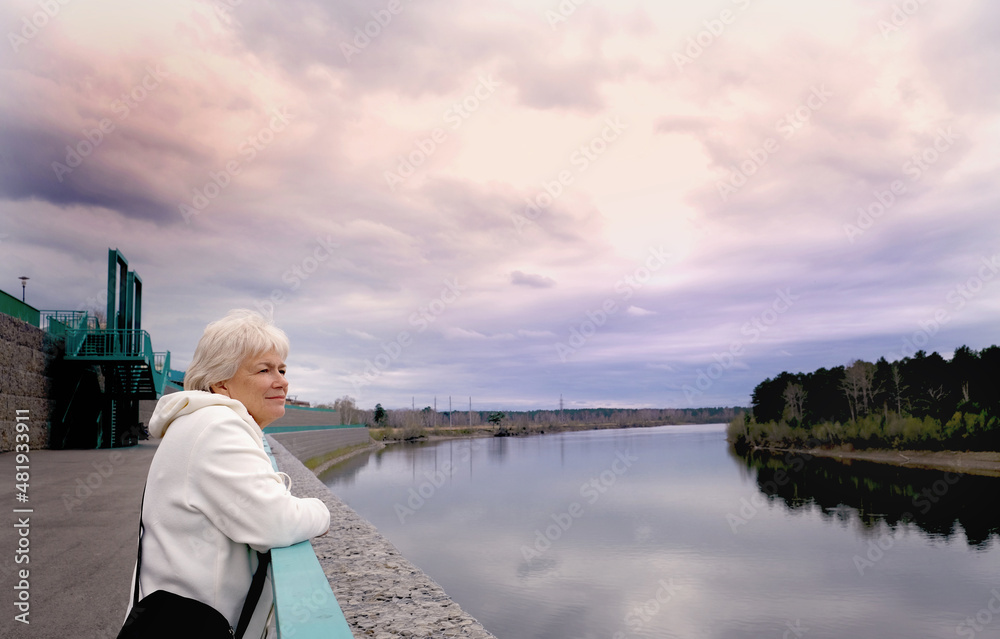 Fototapeta premium Day dreaming senior woman outdoors. Contented senior woman looking thoughtful during walking countryside