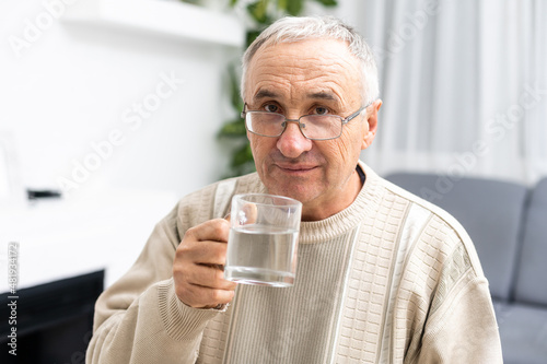 Male senior citizen in shirt drinking water