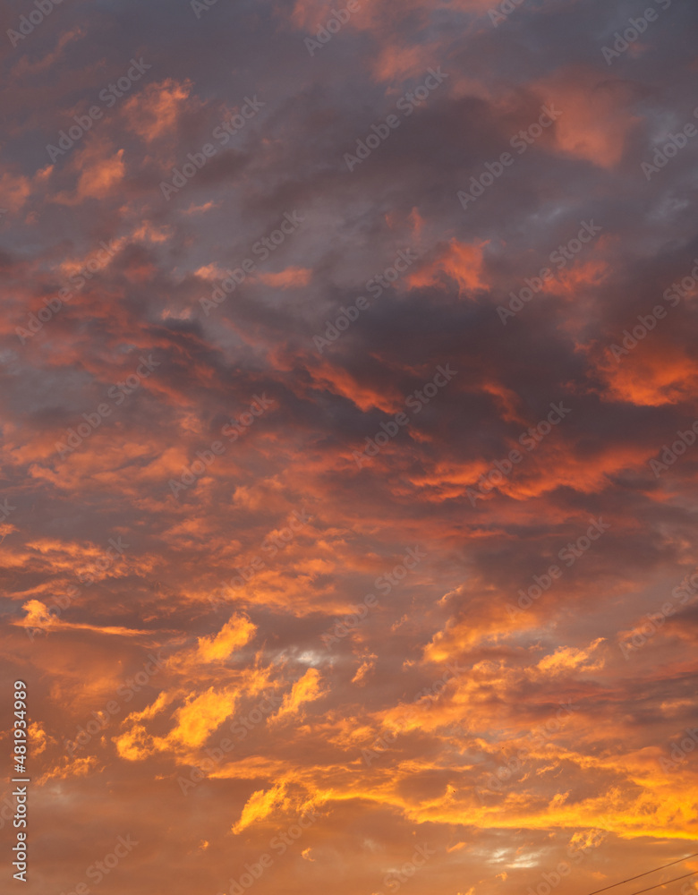Dark orange red clouds with striking shades and a play of light. Vertical snapshot