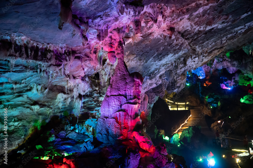 Underground karst cave illuminated by color light