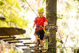 Boy climber walks on the rope bridge,