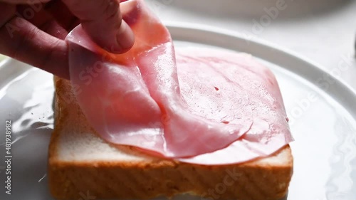 Chef puts ham on bread, slow motion