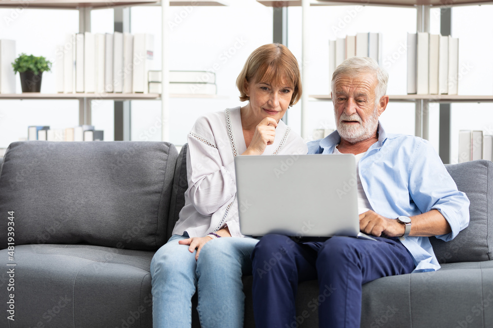 senior couple using laptop computer on sofa senior couple using laptop computer on sofa