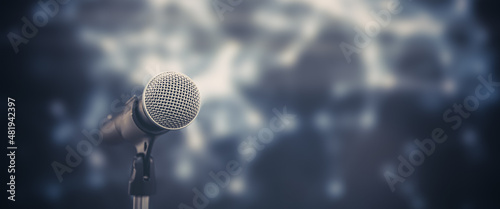 Microphone Public speaking background, Close up microphone on stand for speaker speech presentation stage performance with blur and bokeh light background.