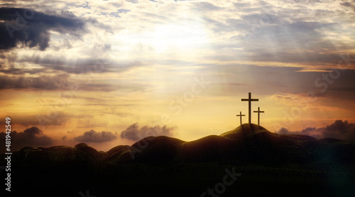 Leinwand Poster The sky over Golgotha Hill is shrouded in majestic light and clouds, revealing the holy cross symbolizing the death and resurrection of Jesus Christ