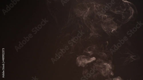 Burning charcoal and incense sticks smoke on dark background.
