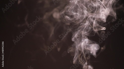 Burning charcoal and incense sticks smoke on dark background.
