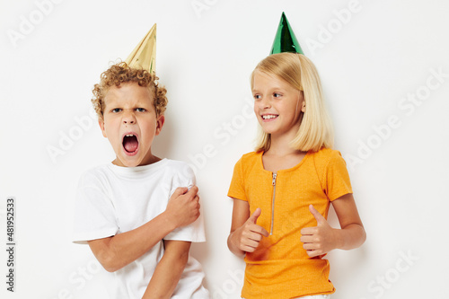Cute stylish kids posing emotions holiday colorful caps isolated background unaltered