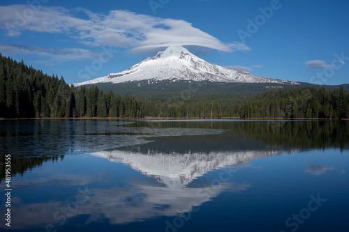 Lenticular clouds in formation over snow-covered Mount Hood on a sunny winter day viewed from the Trillium Lake.