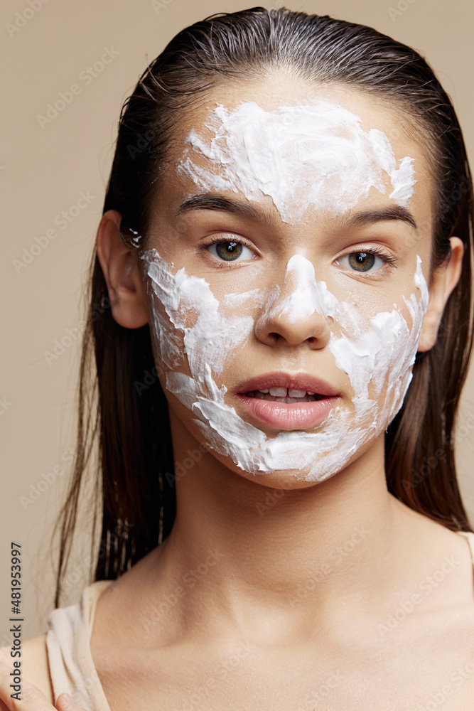 Beautiful Woman with moisturizer on the cheeks in the eye area Youth and Skin Care Concept Beautiful Woman with moisturizer on the cheeks in the eye area Youth and Skin Care Concept