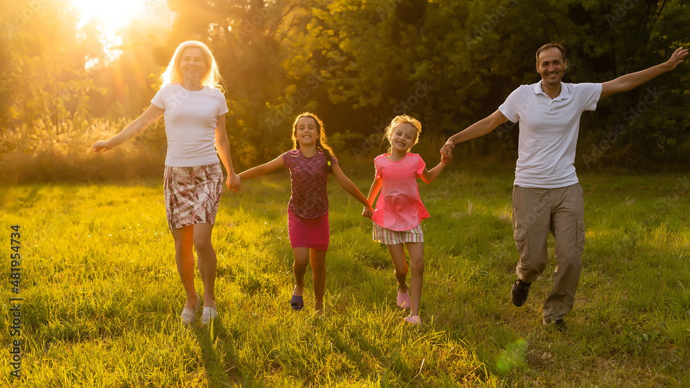 Fototapeta premium Happy family father of mother and children on nature at sunset