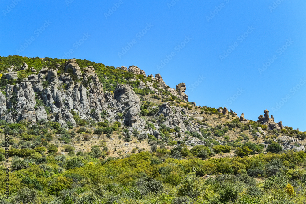 Ancient limestone high mountains of rounded shape in the air haze. The Valley of Ghosts. Demerji. May 2021. Crimea. Russia.