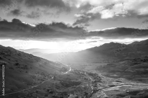 Black and white Beautiful aerial drone landscape image of sunrise from Blea Tarn in Lake District during stunning Autumn showing