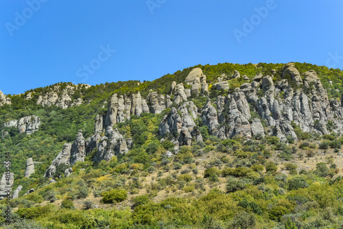 Ancient limestone high mountains of rounded shape in the air haze. The Valley of Ghosts. Demerji. May 2021. Crimea. Russia.