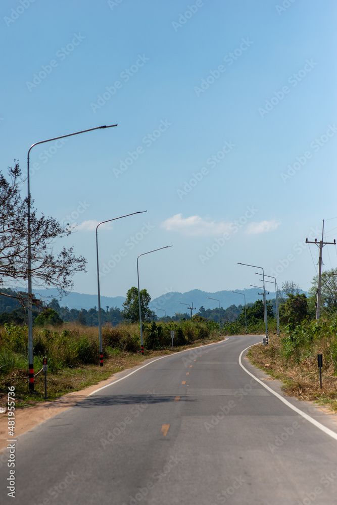empty rural road with light pole and mountain on background vertical frame