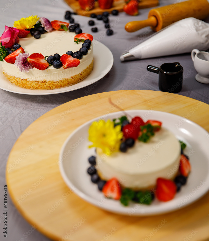 Sweet cheesecake decorated with fresh berry fruits, and flowers on a wooden plate , for birthday, Valentine day and celebration