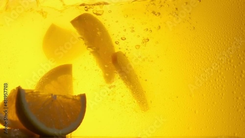 Orange in a glass of juice. Slow motion