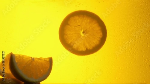 Orange in a glass of juice. Slow motion