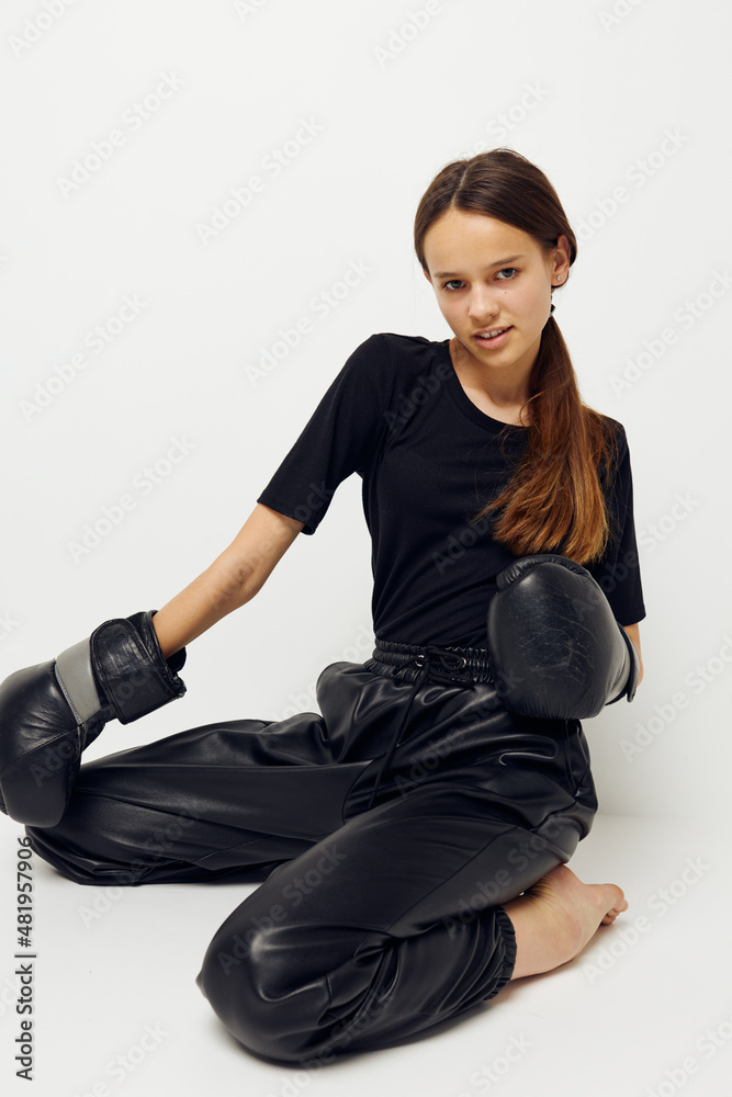photo pretty girl in boxing gloves on the floor in black t-shirt light background