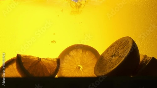 Orange in a glass of juice. Slow motion