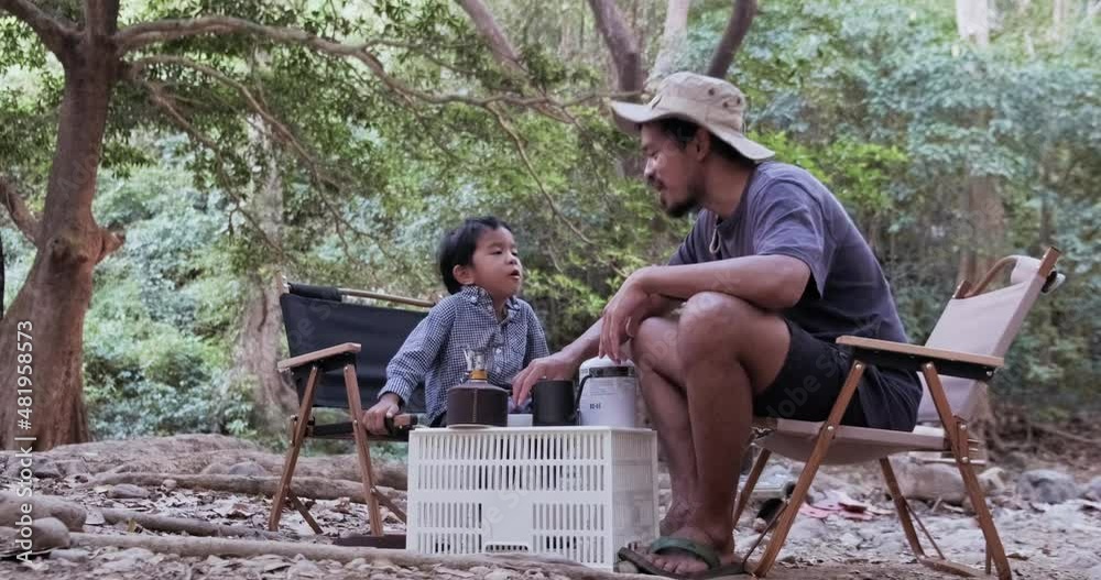 Boy with dad enjoying camping in the forest with camping tent summer vacation Boy with dad enjoying camping in the forest with camping tent summer vacation