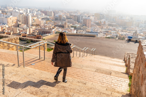 A young tourist walking in the viewpoint of Cerro San Cristobal and the city of Almeria in the background, Andalusia. Spain. Costa del sol in the mediterranean sea