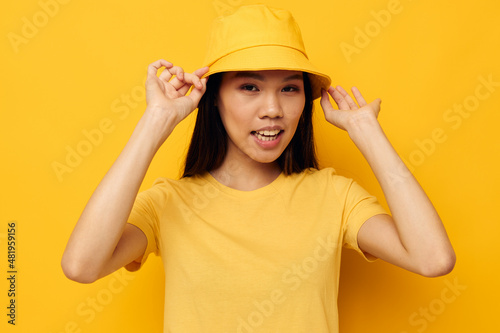 Charming young Asian woman in a yellow t-shirt and hat posing emotions Lifestyle unaltered © Tatiana