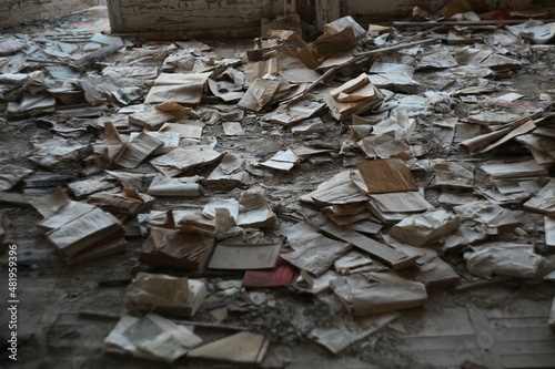 Pile of books lying on floor in abandoned building 