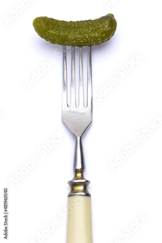 Tasty canned Whole green cornichon on a fork isolated on a white background © Anatoly Repin