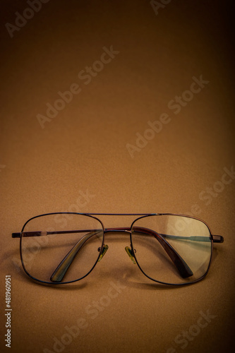 Glasses with transparent glasses lie on a brown background.