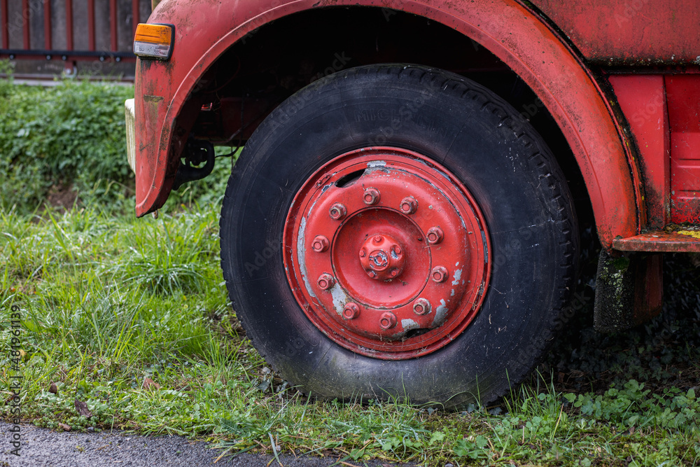 Grosse roue d'un vieux camion rouge ancien, roue vintage avec écrous Grosse roue d'un vieux camion rouge ancien, roue vintage avec écrous