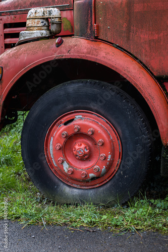 Grosse roue d'un vieux camion rouge ancien, roue vintage avec écrous © lamurebenjamin