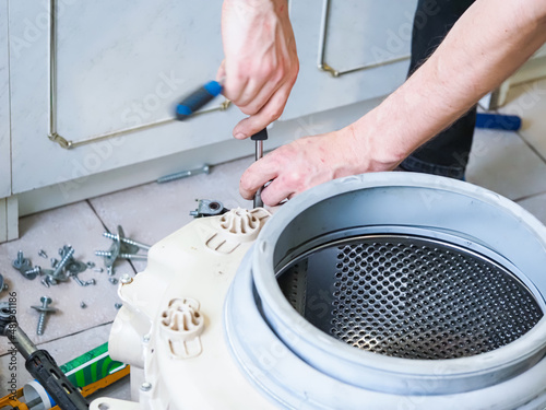 master man disassembles into a washing machine for repair photo