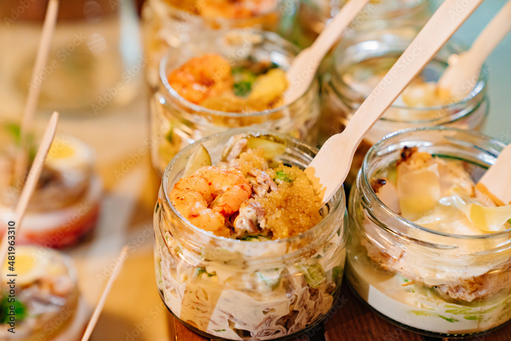 close up. Catering. convenient portioned serving of salads with shrimps in small jars. beautiful original table setting for banquet. close up. Catering. convenient portioned serving of salads with shrimps in small jars. beautiful original table setting for banquet.