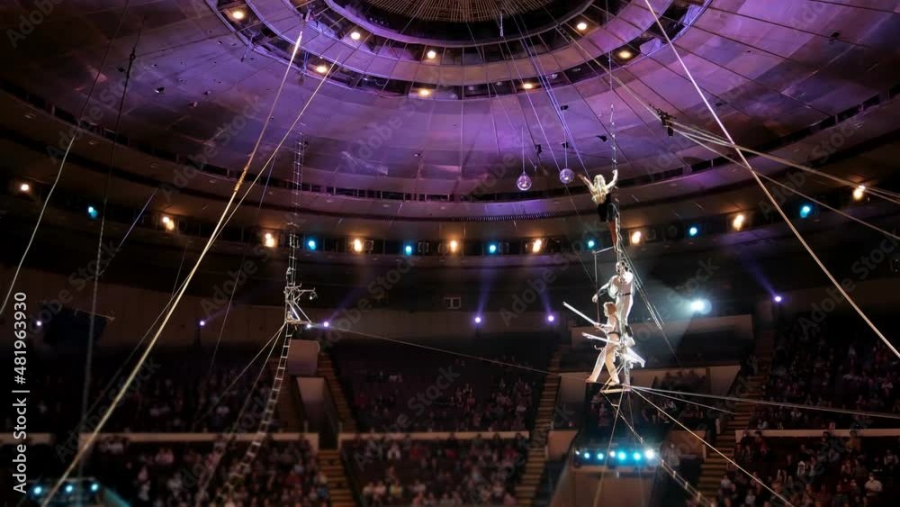 Performance of three aerial tightrope walkers gymnasts in white suits ...
