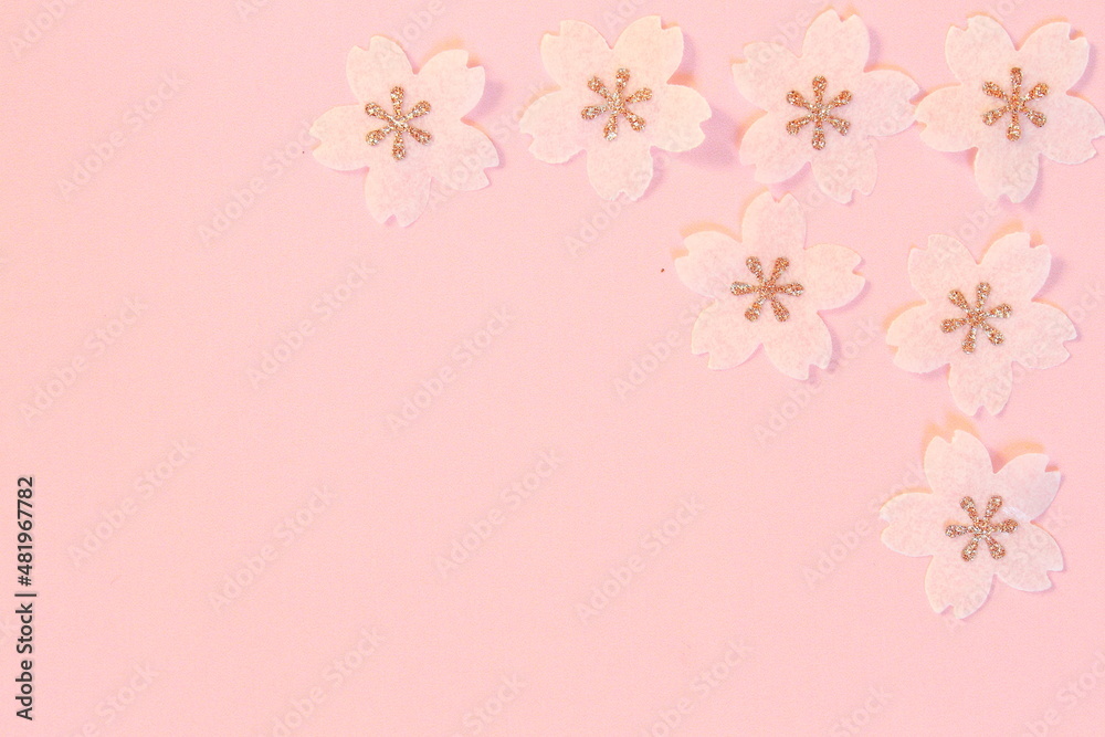 Cherry blossom petals paper crafts on pink textured paper background for wall paper.  Blank for copy space.