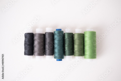 Sewing machine threads in green colors. Flat lay, top view. High quality photo