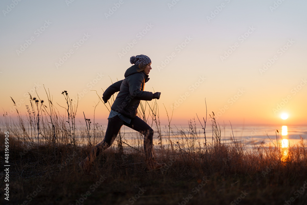 Woman silhouette running in natural beautiful sunset. Motivation