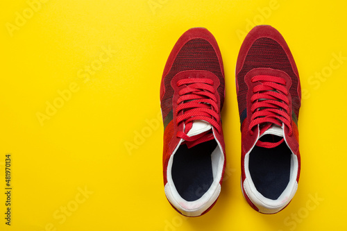 New unbranded running sneaker or trainer on yellow background. Men's sport footwear.