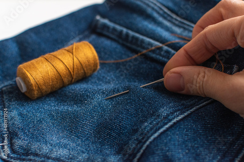 Concept of slow fashion: DIY care and repair of clothes. Selective focus.