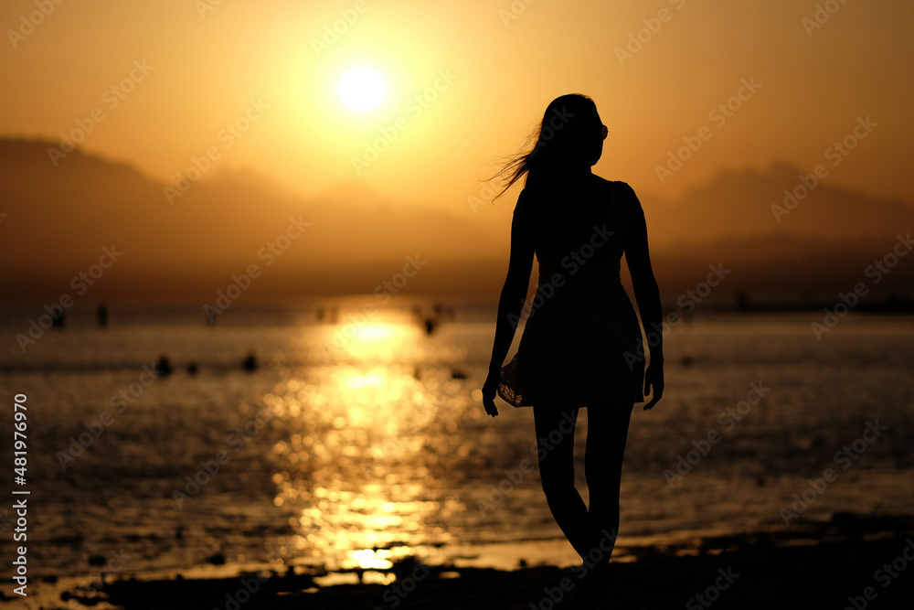 Schöne Frau genießt den Sonnenuntergang am Strand von Soma Bay in Ägypten Schöne Frau genießt den Sonnenuntergang am Strand von Soma Bay in Ägypten