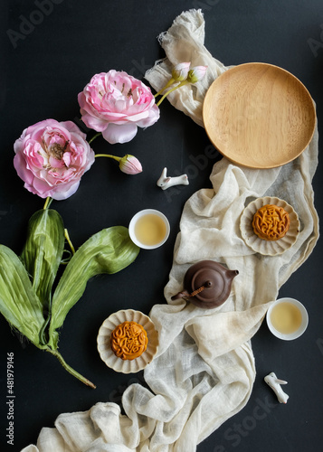 Traditional Chinese festive pastry. Mooncake and Chinese Tea. Celebrating mid autumn festival, the Chinese words are lotus and red bean paste