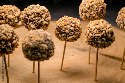 Candy bar of chocolate candy pops on sticks on wooden plate photo