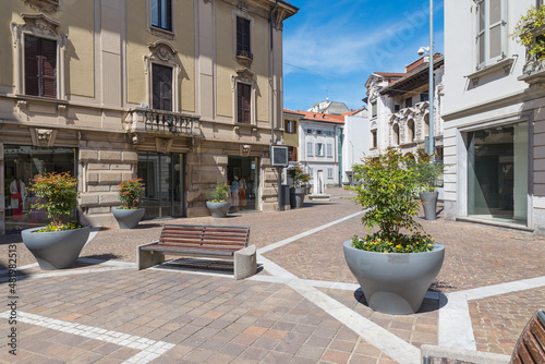 Fototapeta Naklejka Na Ścianę i Meble -  Historic center of an Italian city with street furniture, benches and planters. Gallarate town, street Teatro, northern Italy
