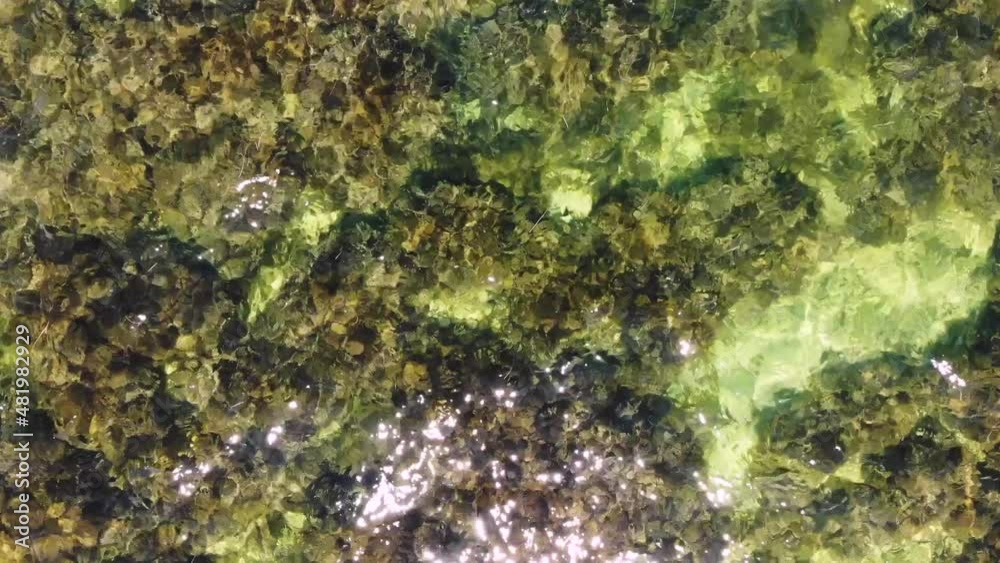 Top view of the transparent sea in shallow water. Aerial view of small waves ripples on the surface of the ocean. Sea background on a sunny day Top view of the transparent sea in shallow water. Aerial view of small waves ripples on the surface of the ocean. Sea background on a sunny day
