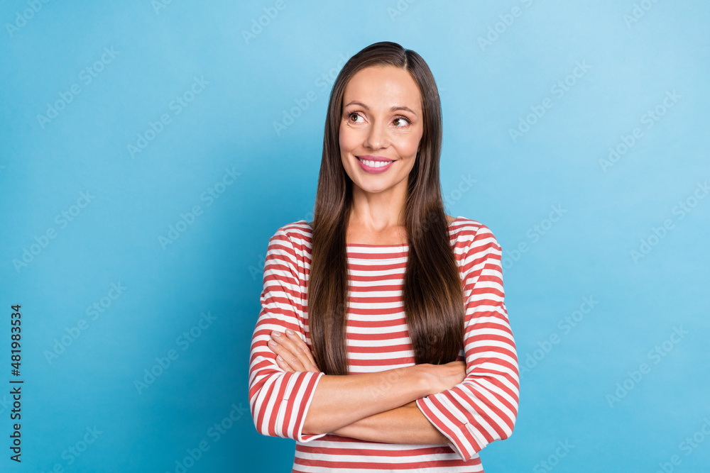 Photo of mature lady hmm creative wondered look empty space crossed hands isolated over blue color background Photo of mature lady hmm creative wondered look empty space crossed hands isolated over blue color background