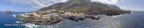 Aerial panoramic view of Santiago del Teide landscape with homes and pools in Tenerife from drone. © jovannig
