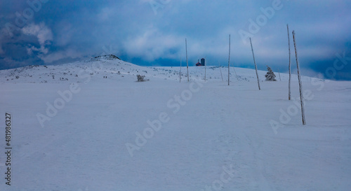 Snowy landscape of mountain trails and hills at cloudy morning